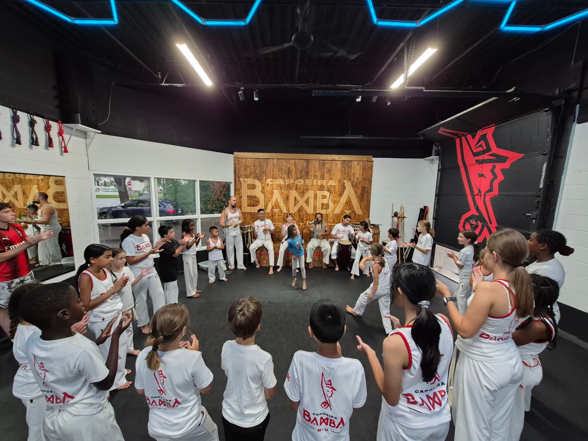 Children and adults training together in a Capoeira roda at Zero Gravity Martial Arts